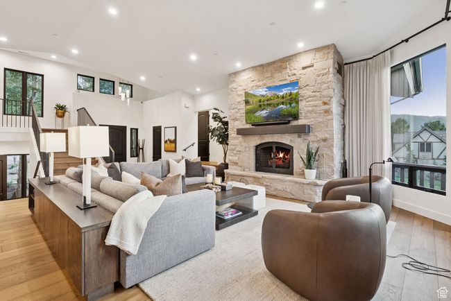 Living room with a fireplace, recessed lighting, wood finished floors, healthy amount of natural light, and vaulted ceiling | Image 18