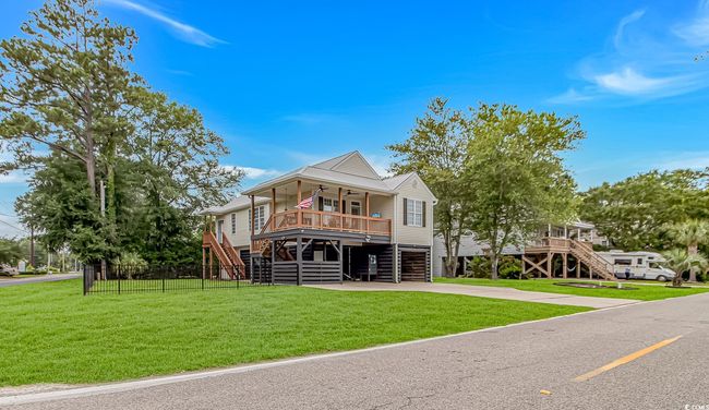 Coastal inspired home featuring stairway, ceiling fan, a porch, driveway, and an attached garage | Image 35