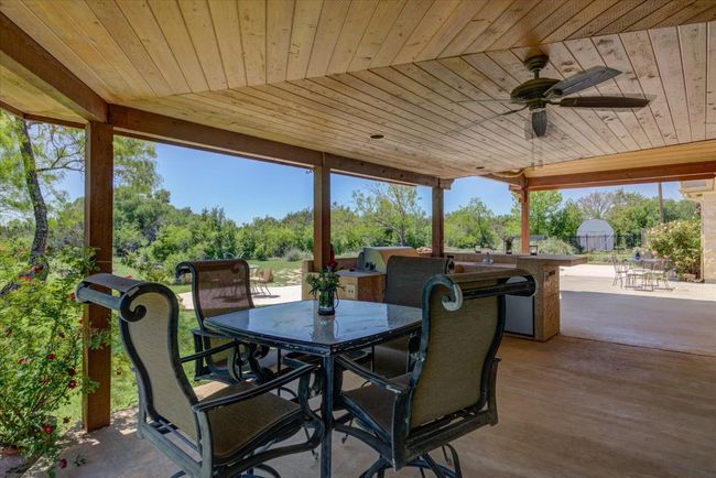 View of patio / terrace featuring outdoor dining and the outdoor kitchen. Lovely wood ceilings make it extra special. | Image 30