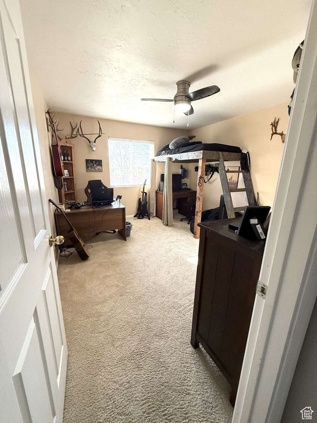 Carpeted home office featuring a textured ceiling and ceiling fan | Image 13