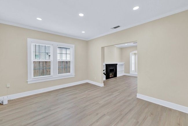 Unfurnished living room with ornamental molding, visible vents, a wealth of natural light, and baseboards | Image 7