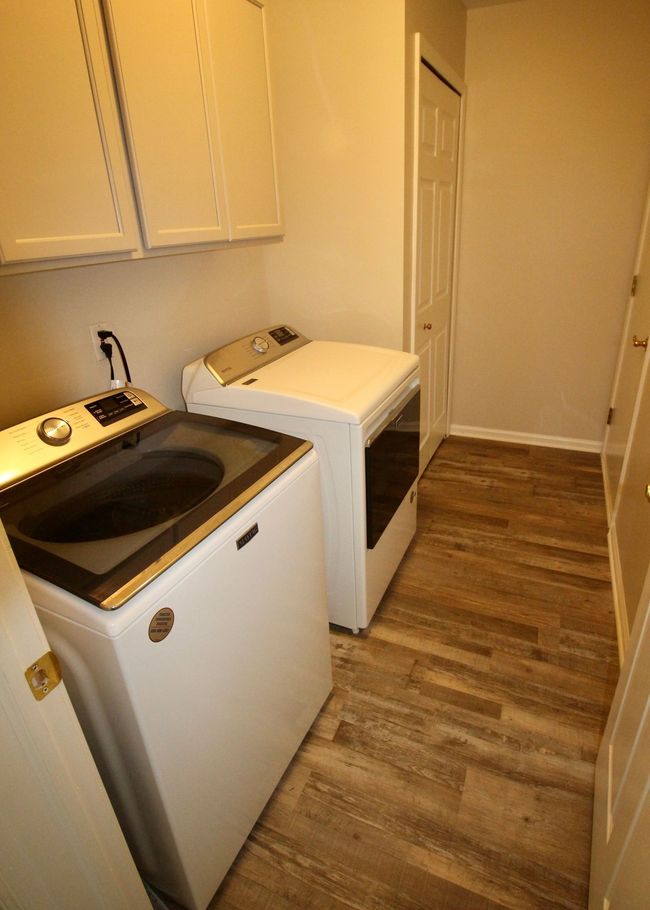 Main floor laundry with cabinets overhead. | Image 22
