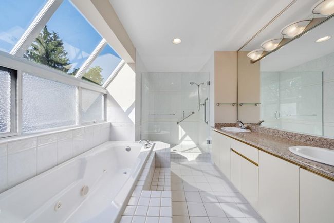 Bathroom featuring a sink, double vanity, a stall shower, a jetted tub, and tile patterned floors | Image 23