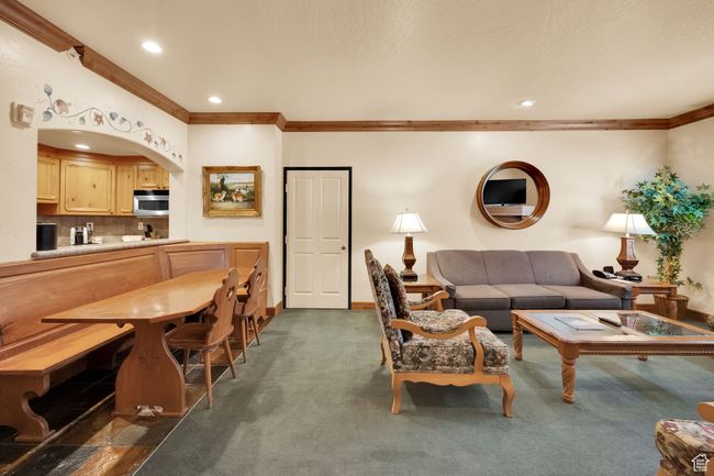Living area featuring baseboards, ornamental molding, recessed lighting, arched walkways, and dark colored carpet | Image 13