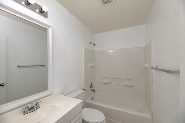 Bathroom featuring visible vents, toilet, vanity, and a textured wall | Image 25