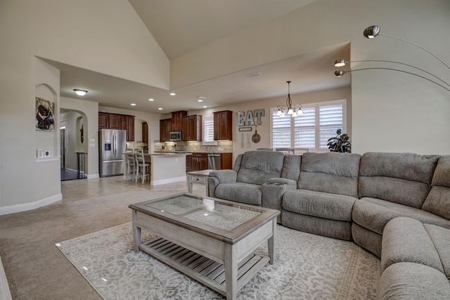 Living room with arched walkways, a chandelier, lofted ceiling, recessed lighting, and light colored carpet | Image 11