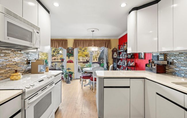 Kitchen featuring white appliances, white cabinets, crown molding, and light countertops | Image 4