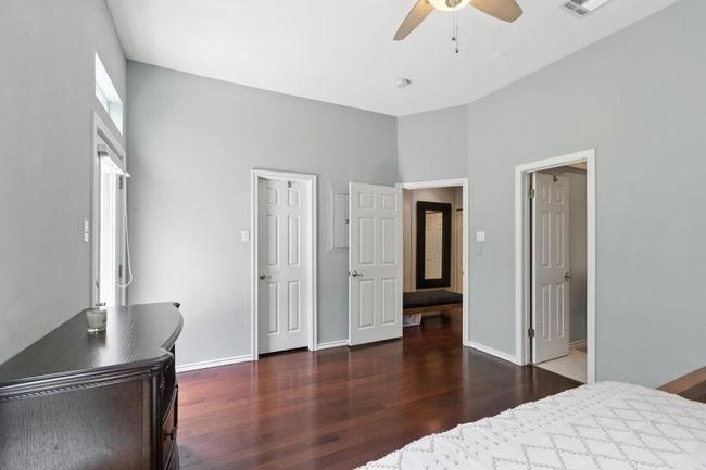 Bedroom with wood finished floors, a ceiling fan, and a high ceiling | Image 22