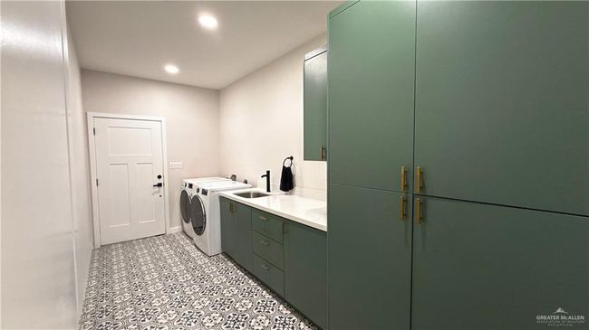 Laundry area featuring washer and dryer, cabinet space, and recessed lighting | Image 9