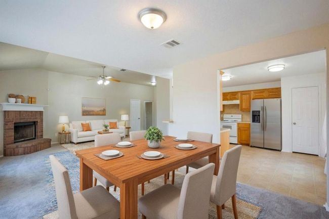 Dining space featuring ceiling fan and a brick fireplace | Image 9