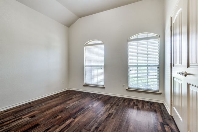 Unfurnished room featuring dark wood-style floors and lofted ceiling | Image 15