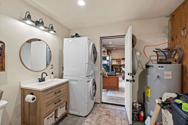 Laundry room with stacked washer and clothes dryer, water heater, and recessed lighting | Image 25