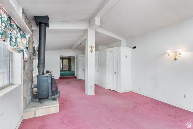 Unfurnished living room with a wood stove and carpet flooring | Image 15