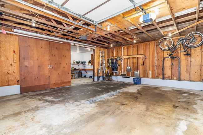 The detached 2-car garage (20'11"x23'6") features two 8-ft doors with garage door openers, ample rafter storage, a floor drain & two sliding barn doors leading to a convenient workshop. | Image 30