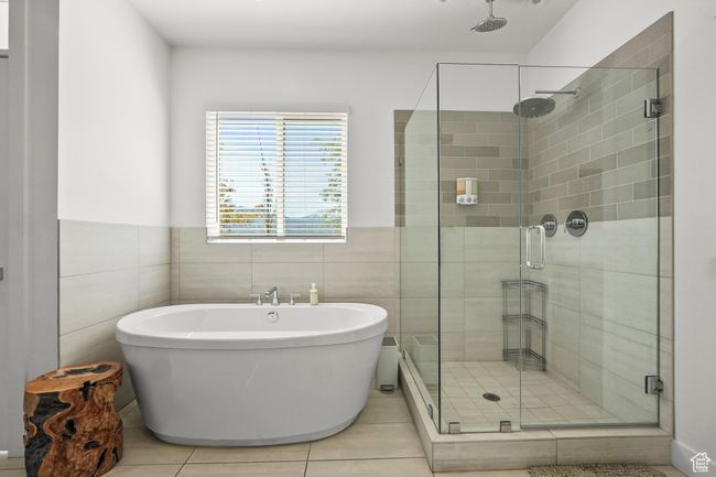 Full bath with a stall shower, a freestanding bath, tile patterned flooring, tile walls, and wainscoting | Image 19