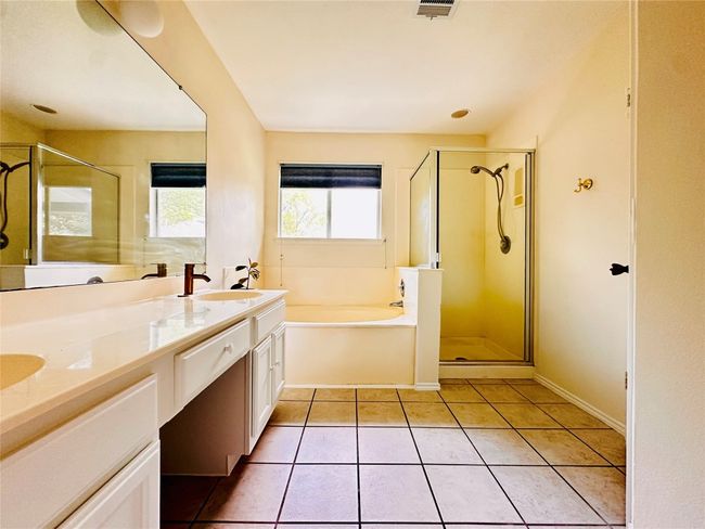 Bathroom featuring a sink, a bath, tile patterned flooring, and a stall shower | Image 21