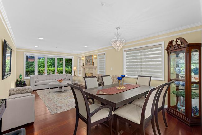 Dining area featuring a fireplace, ornamental molding, a chandelier, dark wood-style floors, and recessed lighting | Image 6