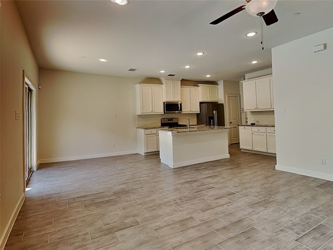 Kitchen featuring appliances with stainless steel finishes, ceiling fan, open floor plan, baseboards, and recessed lighting | Image 4
