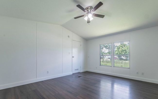 Unfurnished room featuring lofted ceiling, ceiling fan, and dark wood-style floors | Image 11