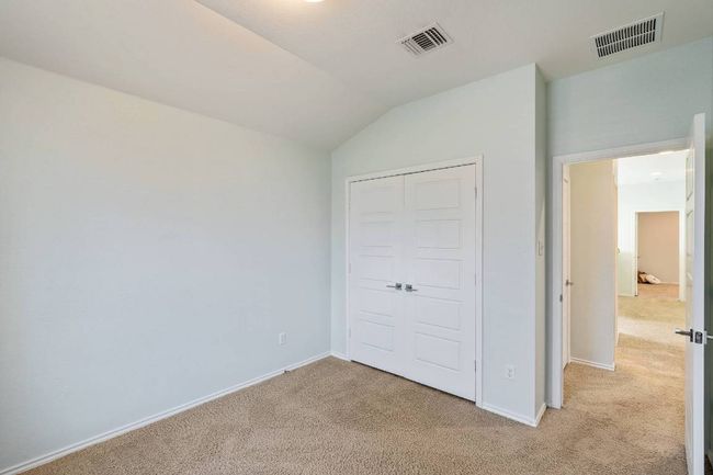 Unfurnished bedroom with light colored carpet, vaulted ceiling, and a closet | Image 29