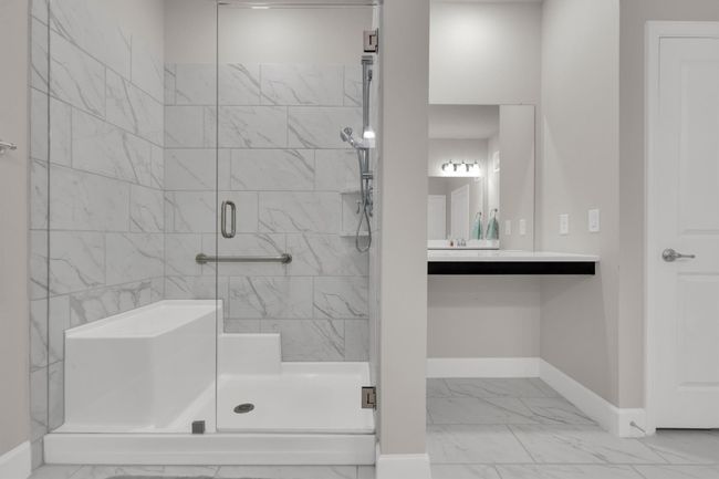 Full bathroom featuring marble look tiles, a stall shower, and vanity | Image 25