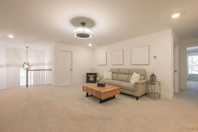 Living room with light colored carpet, recessed lighting, and a chandelier | Image 37