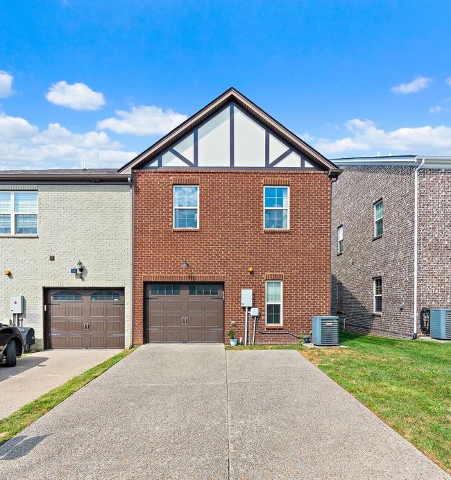 Your property comes with an attached garage (complete with added shelves for more storage space) and a large parking pad. | Image 22