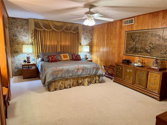 Carpeted bedroom featuring wood walls and ceiling fan | Image 31