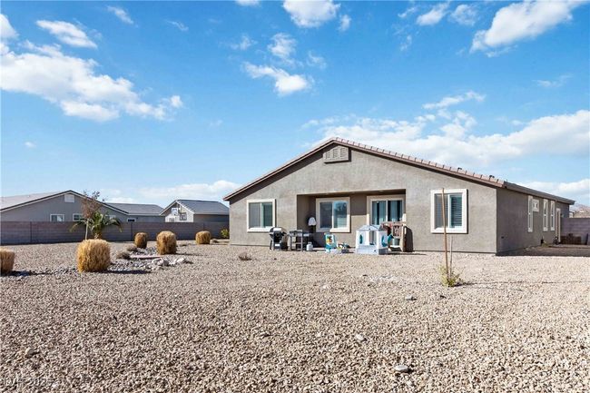 Back of property with fence, a patio, and stucco siding. | Image 47