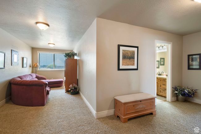 Living area featuring a textured ceiling and light carpet | Image 20