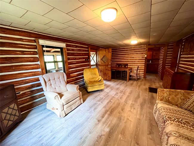 Unfurnished living room with wood finished floors and rustic walls | Image 12
