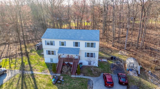 View of front of home with a front yard, a storage shed, an outdoor structure, stairway, and roof with shingles | Image 44
