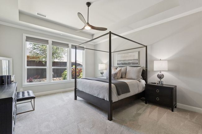 Carpeted bedroom with a tray ceiling, ornamental molding, and ceiling fan | Image 16