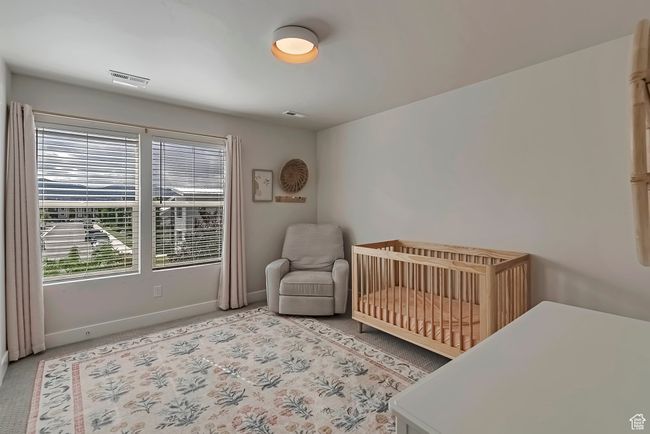 Bedroom with baseboards, a crib, and light colored carpet | Image 21