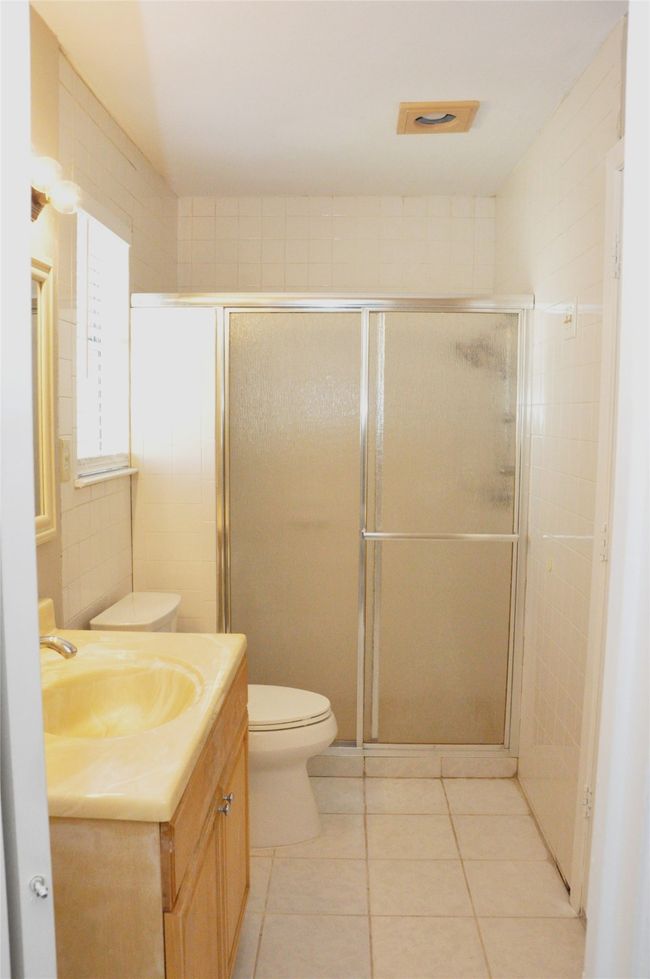 primary bathroom with tile patterned floors, vanity, toilet, and a shower stall | Image 19
