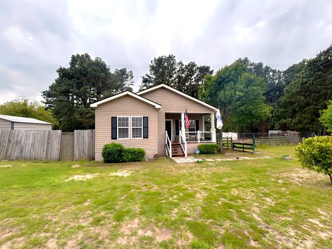 Bungalow with covered porch, fence, and a front lawn | Image 39