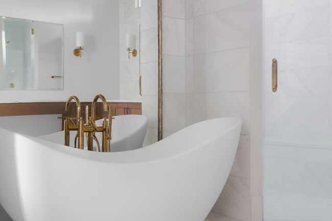 Full bathroom featuring tile walls, a freestanding tub, and an enclosed shower | Image 19