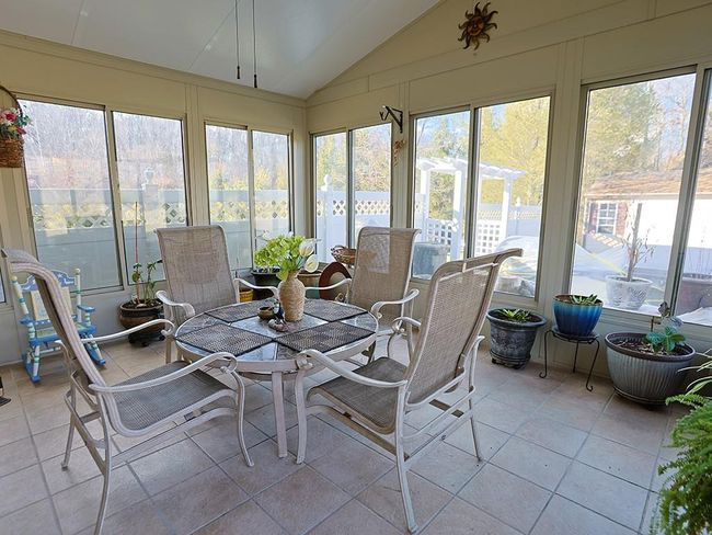 Sunroom / solarium featuring outdoor dining area | Image 12