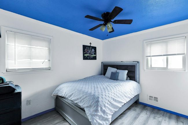Bedroom with wood finished floors, baseboards, ceiling fan, and crown molding | Image 8