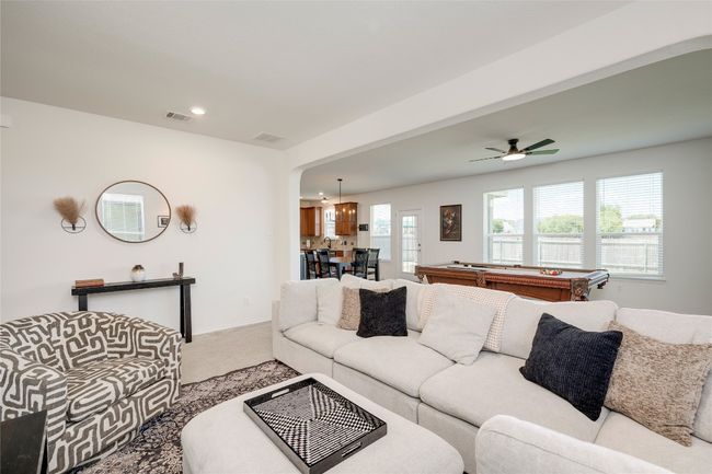 Carpeted living area featuring a ceiling fan, billiards table, and recessed lighting | Image 6