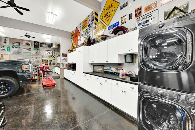 Washroom featuring stacked washer / drying machine, sink, and ceiling fan | Image 52