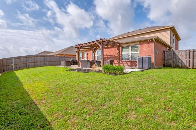 Rear view of property with a pergola, a patio area, brick siding, and a fenced backyard | Image 35