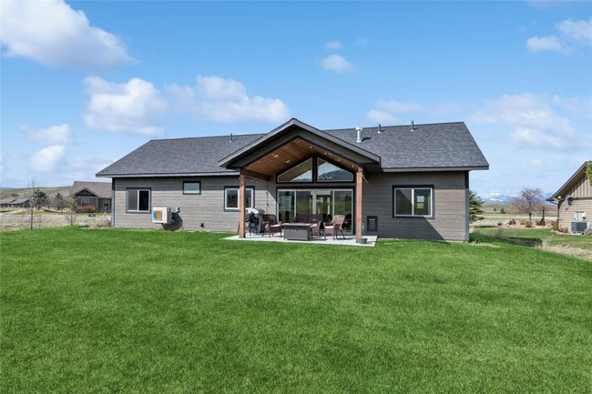 Rear view of house featuring central air condition unit, a patio, a yard, and roof with shingles | Image 7