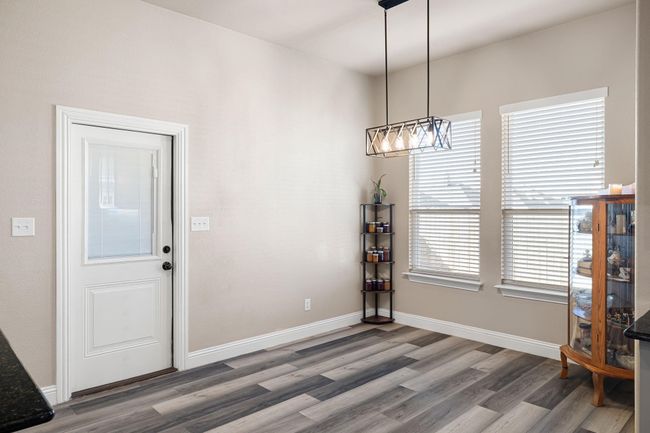 Dining space featuring an inviting chandelier, wood finished floors, and baseboards | Image 16
