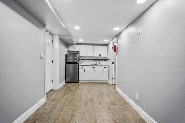 Kitchen with white cabinets, recessed lighting, a sink, freestanding refrigerator, and baseboards | Image 16