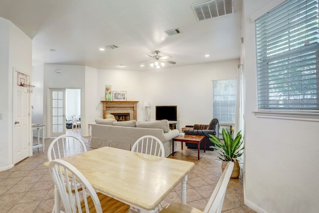 Dining space featuring light tile patterned floors, a ceiling fan, recessed lighting, and a tiled fireplace | Image 9