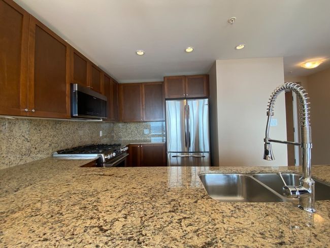 Kitchen featuring appliances with stainless steel finishes, a sink, light stone countertops, tasteful backsplash, and recessed lighting | Image 4