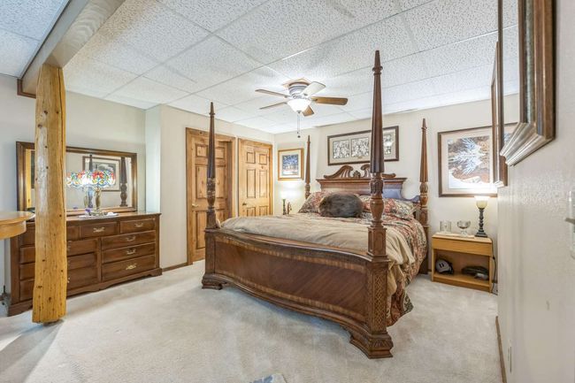 Bedroom with carpet floors, a drop ceiling, and ceiling fan | Image 38