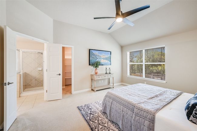 Bedroom featuring light colored carpet, lofted ceiling, a ceiling fan, and connected bathroom | Image 14