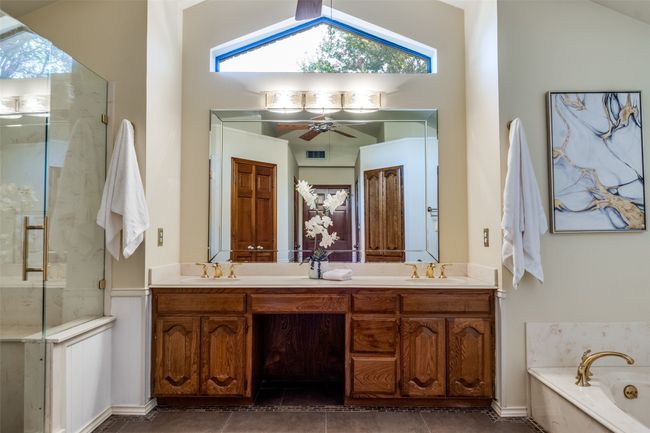 Full bathroom featuring double vanity, a shower stall, a garden tub, tile patterned flooring, and vaulted ceiling | Image 21